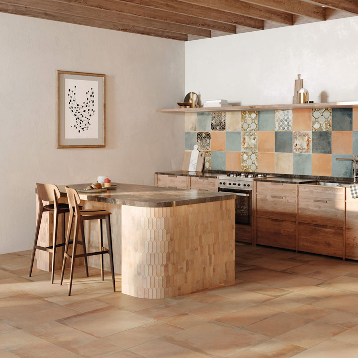 Cucina in stile rustico contemporaneo con mobili in legno, isola centrale con sgabelli, piano in pietra e rivestimento a parete in gres multicolore HEARTLAND AMBER MULTIFORMATO 30X30 DECORI pavimento in gres soffitto con travi a vista.