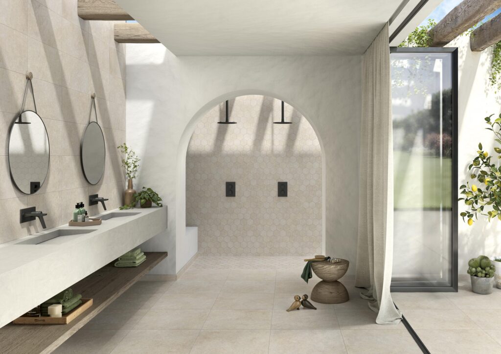 Bagno moderno realizzato con la collezione Cathédrale, colore Reims Blanc nel formato 60x60. Il pavimento e i dettagli chiari creano un ambiente igienico e luminoso con doppio lavabo e specchi tondi.