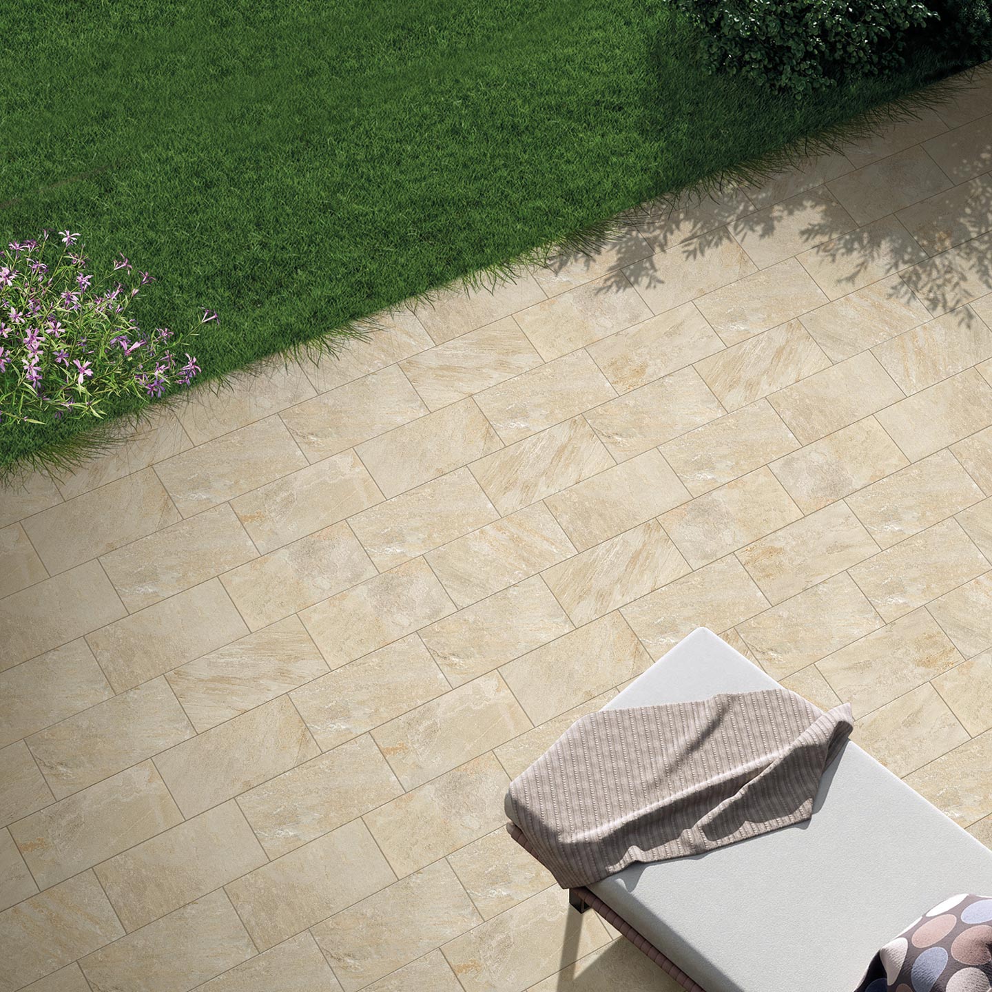 La collezione VENTIQUARANTA, nella raffinata tonalità Seattle Beige e formato 20x40, valorizza questo spazioso terrazzo outdoor dal design moderno e solare. La pavimentazione esterna, caratterizzata da piastrelle effetto pietra posate a moduli geometrici alternati, accoglie sul lato sinistro una fila di eleganti lettini prendisole in legno con cuscini beige, disposti lungo una grande vetrata. Sulla destra, grandi fioriere squadrate in corten ospitano rigogliosi alberi di limone carichi di frutti, che proiettano ombre nitide sulla superficie ceramica, ricreando un'atmosfera calda, lussuosa e tipicamente mediterranea.